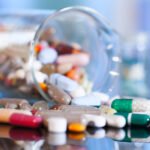 Colorful tablets with capsules and pills on blue background